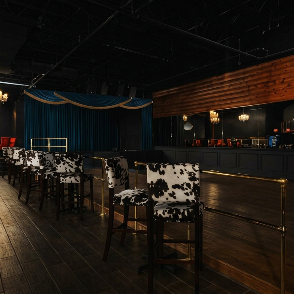 Upscale restaurant lounge with cow-print bar stools, velvet curtains, chandeliers, wooden walls, and a mirrored bar.