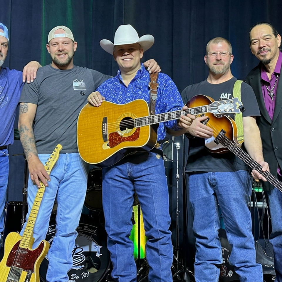 Five musicians pose onstage with acoustic and electric guitars, a bass, and a drum kit behind them.